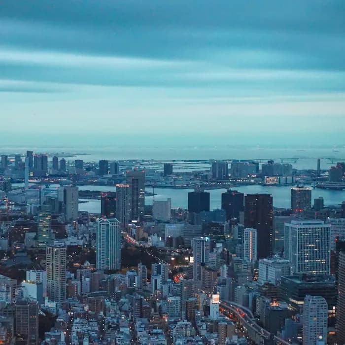 Tokyo Tower lit at dusk above the city skyline