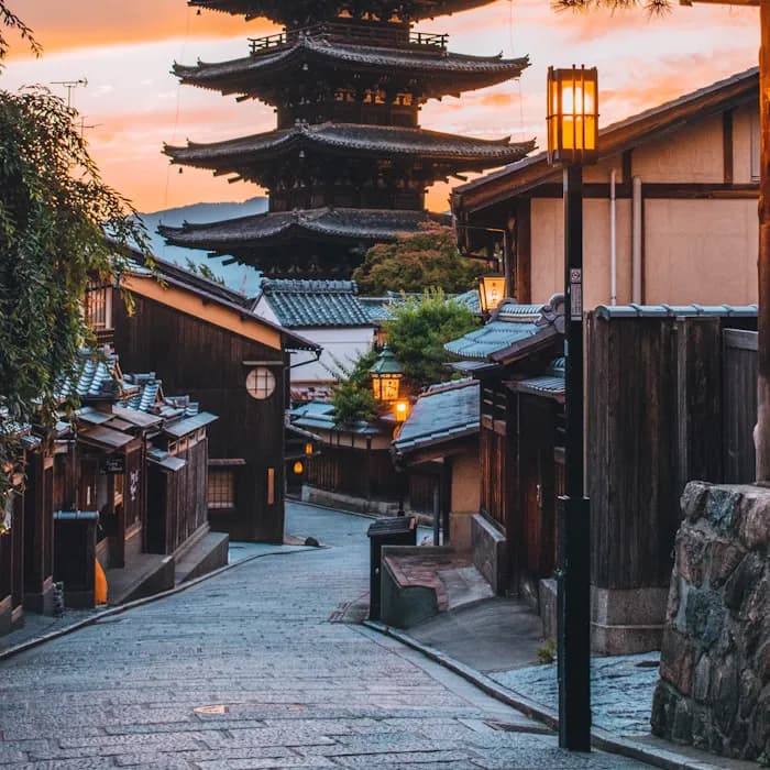 A pagoda rising above a lantern-lit street in Kyoto